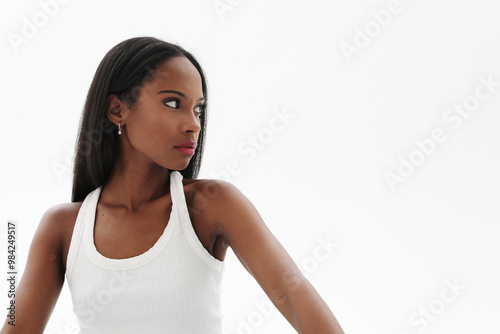 Beautiful young dark skinned woman looking away and posing indoor. Mock-up.