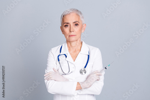 Photo of retired confident woman qualified specialist crossed arms injection vaccine inection isolated on grey color background photo