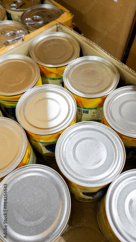 Stack of canned goods in a cardboard box, representing food storage and preparation for emergencies or holiday donations Stack of canned goods in a cardboard box, representing food storage and preparation for emergencies or holiday donations