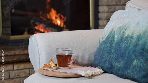 Cup of tea on the sofa and fireplace in the background