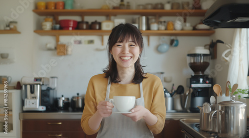 Japanese woman makes coffee and smiles for the camera in her plain kitchen