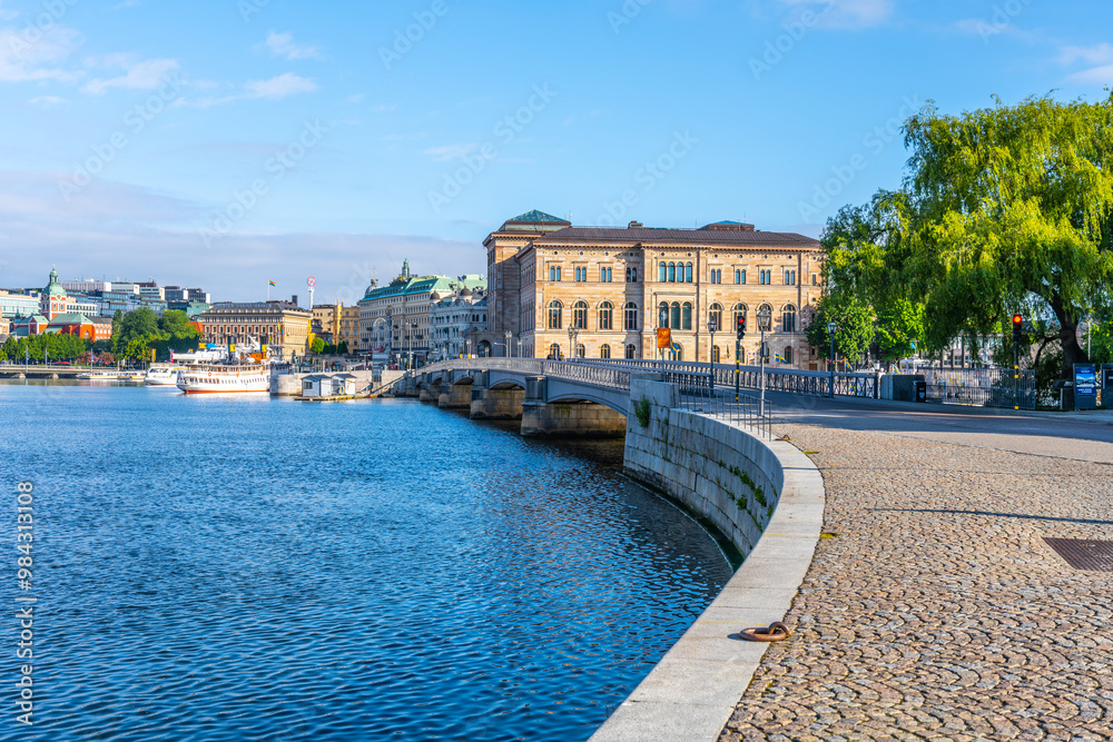 Φωτογραφία The Skeppsholmen Bridge stretches over the water with the National Museum of Sweden in the background on a bright sunny day