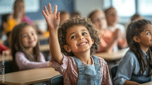 Cheerful diverse primary school children students in modern light classroom with one hand up to asnwer teacher's question photo