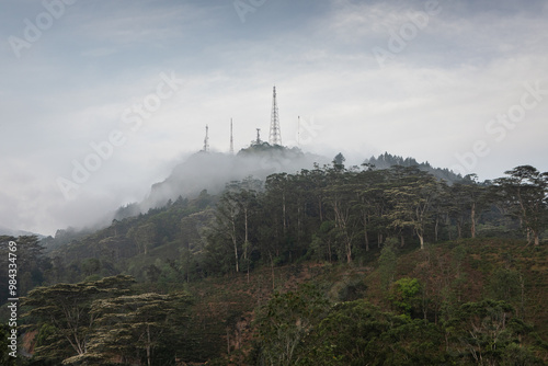 Morning mist moving through the hills engulfing forests and communication towers. photo