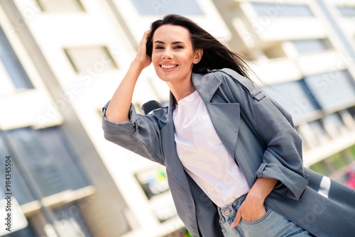 Photo of adorable lovely girl wear grey trench choosing new apartment enjoying sunny weather outdoors urban city street