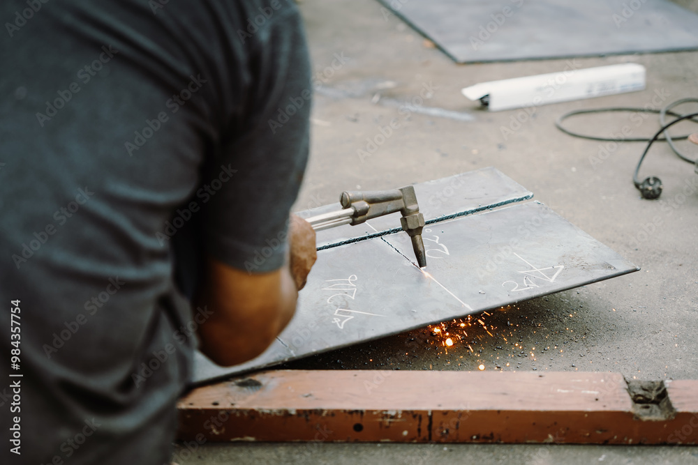 Man cutting steel with gas, Oxy fuel cutting metals working outside factory with out hand shield, or goggles, Safety Health and Environmental concept