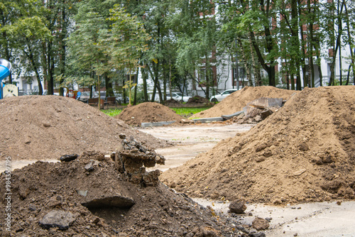 A pile of dirt currently sits on the ground next to a residential home