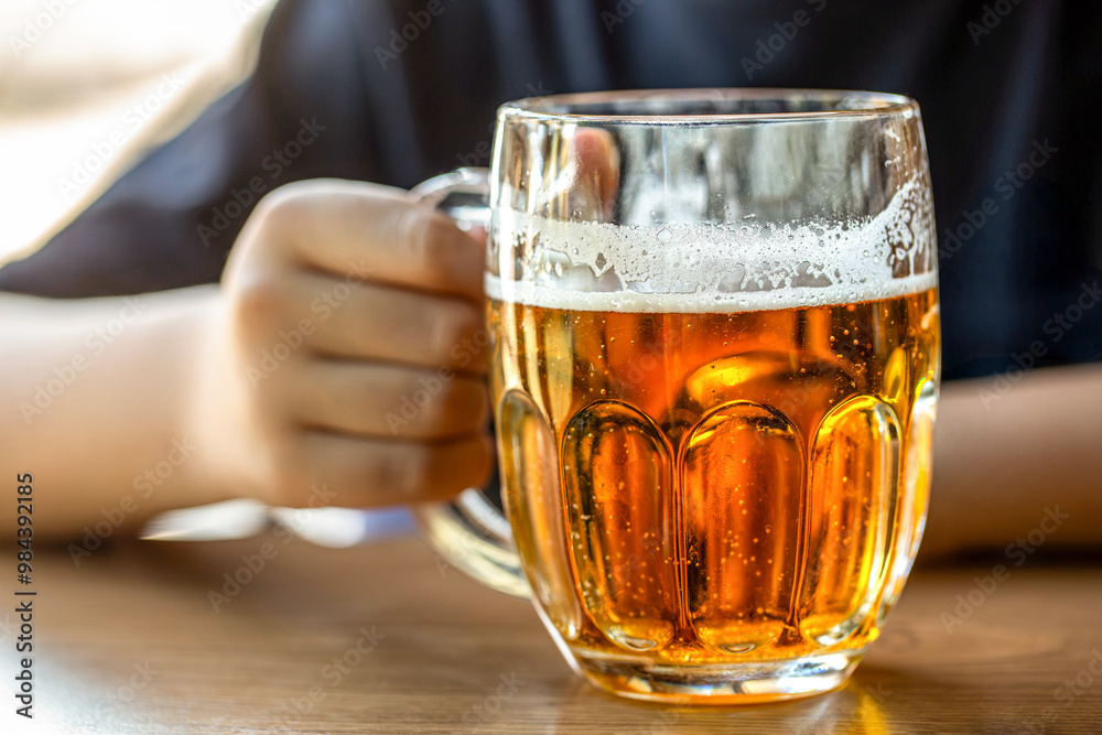 Man hand holding glass with beer in a bar or pub, bartender. Closeup of a man holding glass of beer. Hand of a male with full glass of beer at the pub. Close up of a woman hand holding glass beer Man hand holding glass with beer in a bar or pub, bartender. Closeup of a man holding glass of beer. Hand of a male with full glass of beer at the pub. Close up of a woman hand holding glass beer