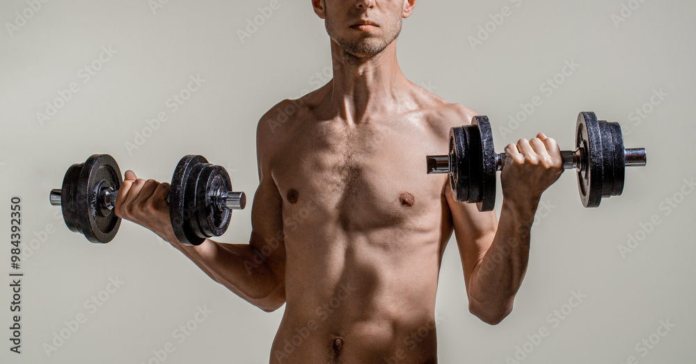 Skinny man, dumbbells. Skinny man goes in for sports, builds muscles. Health care concept. Workout gym sport motivation concept. Man holding dumbbell in hand. Thin man in sports with dumbbells Skinny man, dumbbells. Skinny man goes in for sports, builds muscles. Health care concept. Workout gym sport motivation concept. Man holding dumbbell in hand. Thin man in sports with dumbbells