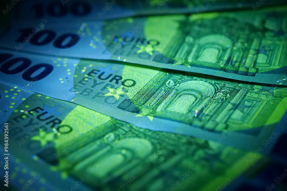 Security signs and elements on euro banknotes glow under ultraviolet light Security signs and elements on euro banknotes glow under ultraviolet light