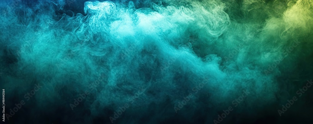 Obraz premium A mystical abstract background of colorful smoke swirling in shades of blue, green, and yellow, ideal for creative projects.