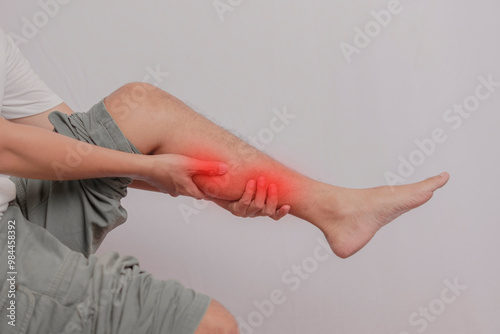 Inflammation of the calf of the leg held by the hand. Pain that attacks the calf of a young man's leg. health concept on leg bones.