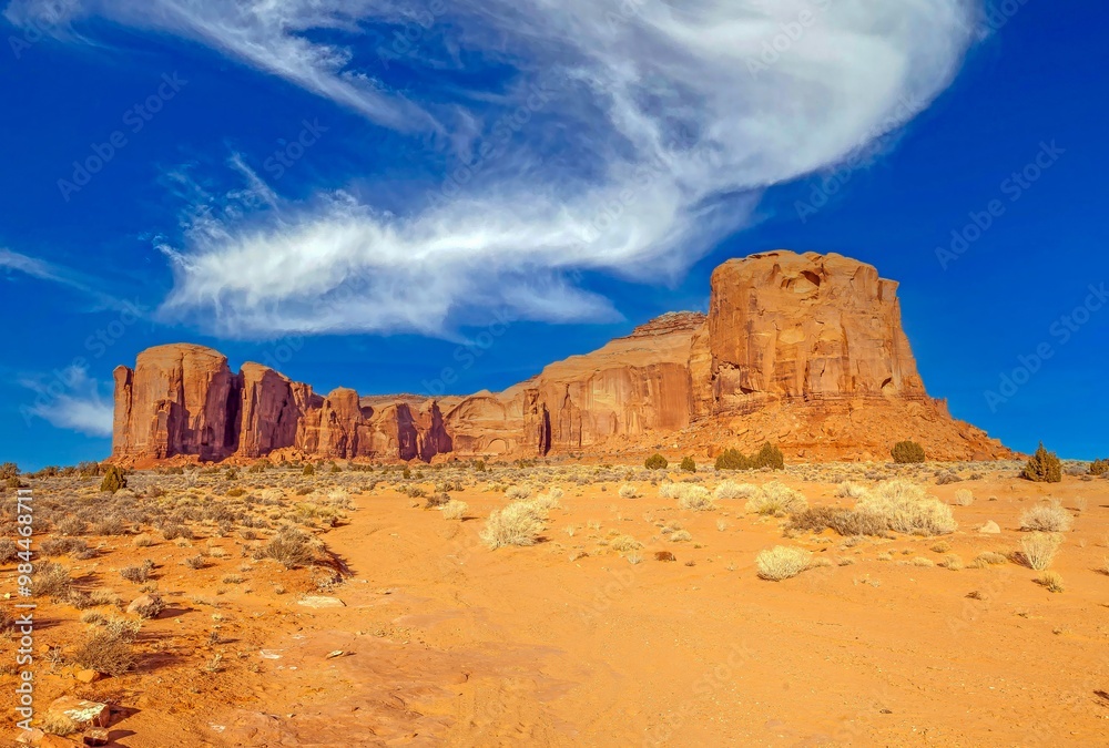 Fototapeta premium Panoramic picture of the glowing red geological sandstone formations in Monument Valley