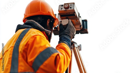 Orange clad Surveyor Using Surveying Equipment on Construction Site