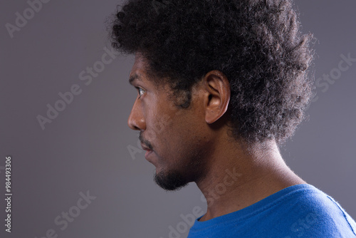 Young man with afro hairstyle looking left profile view