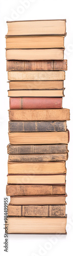 A stack of books with a white background. The books are old and have a worn look. The stack is tall and seems to be leaning to one side