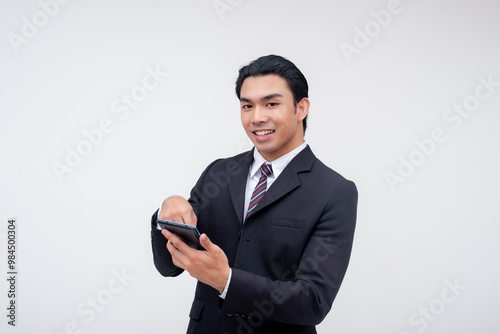 A young asian business executive smiling while swiping on his cellphone. Isolated on a white background.