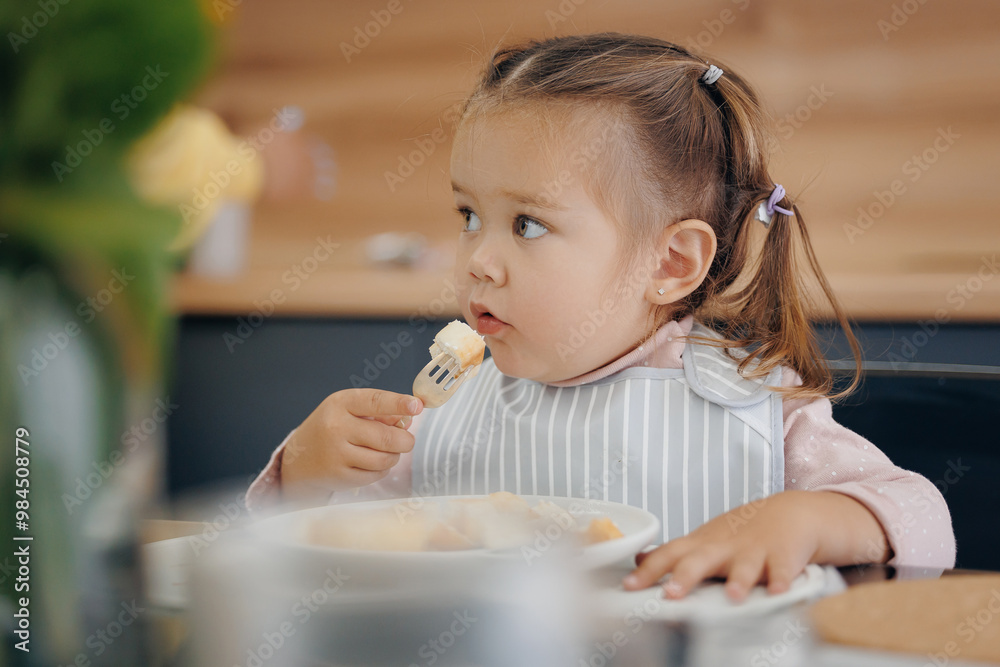 Little girl holds fork on her own and eats healthy breakfast from milk. Concept independent kid, eating super food Little girl holds fork on her own and eats healthy breakfast from milk. Concept independent kid, eating super food