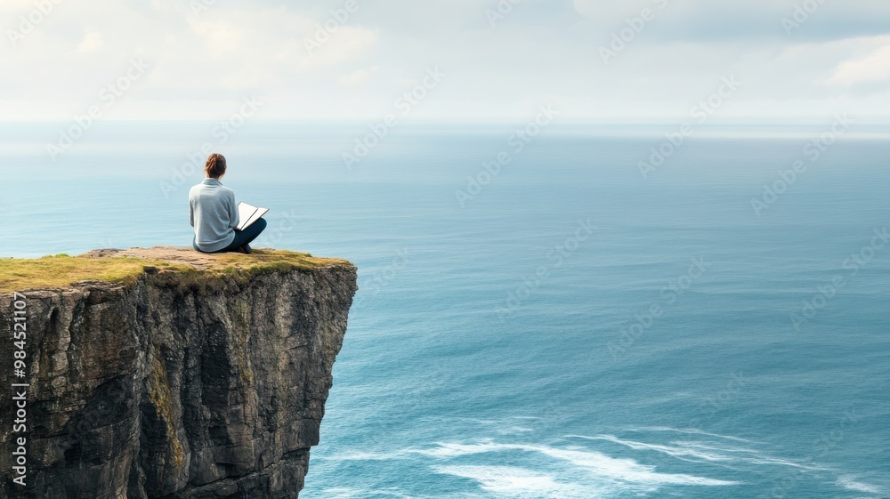 A person sits peacefully at the edge of a cliff, overlooking a serene ocean, embodying tranquility and solitude in nature. A person sits peacefully at the edge of a cliff, overlooking a serene ocean, embodying tranquility and solitude in nature.