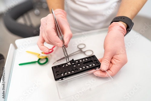 A dentist is holding a pair of dental pliers and a pair of scissors. The dentist is preparing to extract a tooth