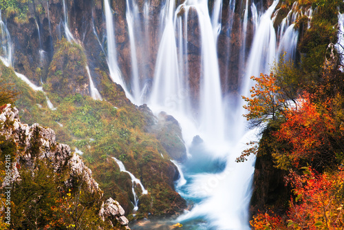 Obraz na płótnie Scenic Autumn Waterfall in Serene Forest Setting w salonie