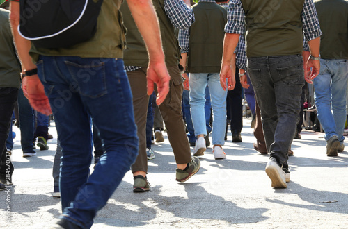 many legs of people walking on the street in protest during a demonstration