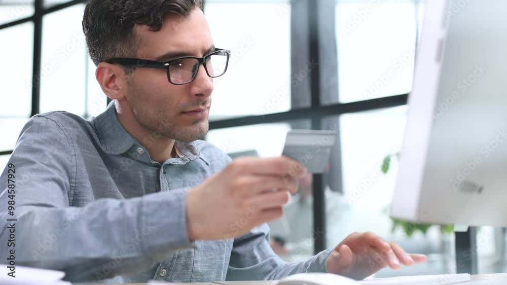 Businessman doing online banking, making a payment or purchasing goods on the internet entering his credit card details on a laptop