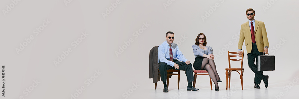 Obraz premium Banner. Business experts seated with air of authority, showcasing classic business style with modern against white background with copy space. Concept of corporate culture, leadership. Ad