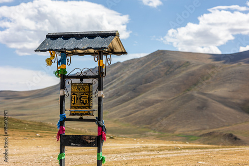 prayer wheel in vast steppe with mountains photo