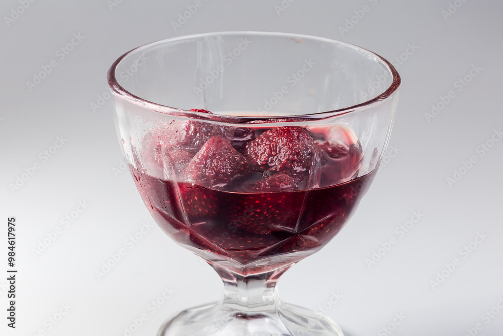Strawberry jam in glass dessert bowl, side view close-up Strawberry jam in glass dessert bowl, side view close-up