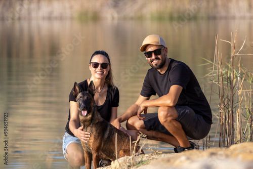 Happy couple with a dog in a lake