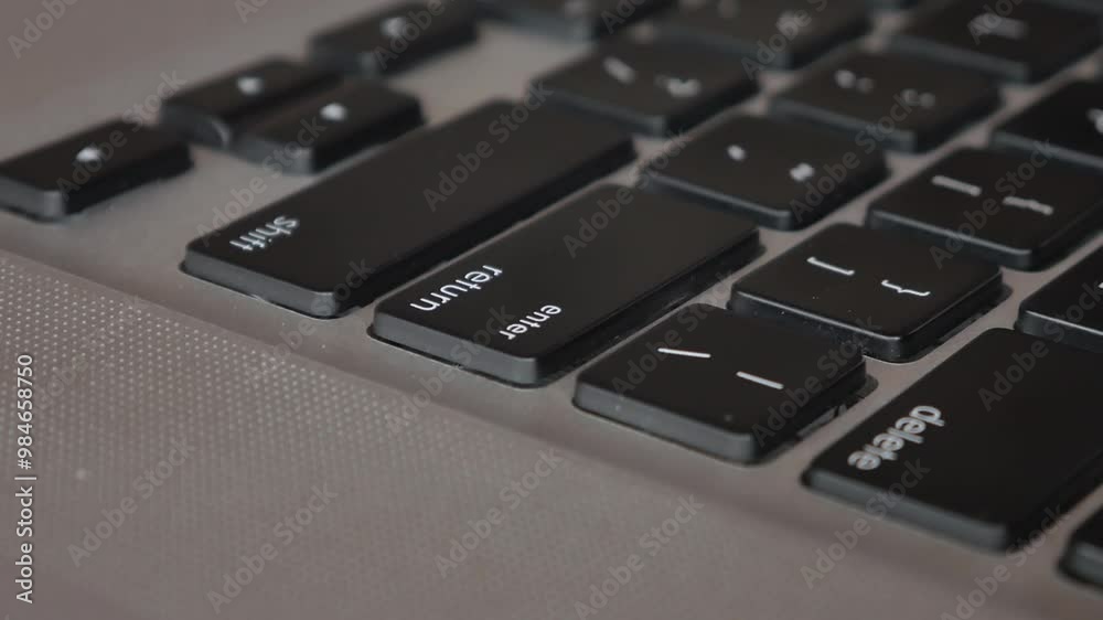 Man's hand forefinger pressing enter key on modern laptop computer keyboard, extreme closeup macro detail, shallow DOF, one person. Sending messages, purchasing, receiving rules, executing program. Man's hand forefinger pressing enter key on modern laptop computer keyboard, extreme closeup macro detail, shallow DOF, one person. Sending messages, purchasing, receiving rules, executing program.