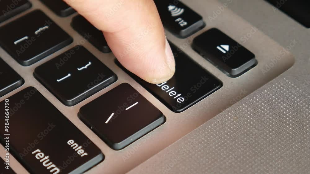 Finger of the computer user, he presses the delete button on the computer keyboard. Finger of the computer user, he presses the delete button on the computer keyboard.