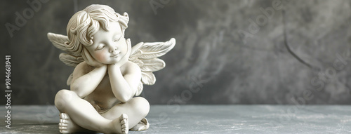 Mourning angel statue on gray concrete background, banner with copy space for All Saints Day
