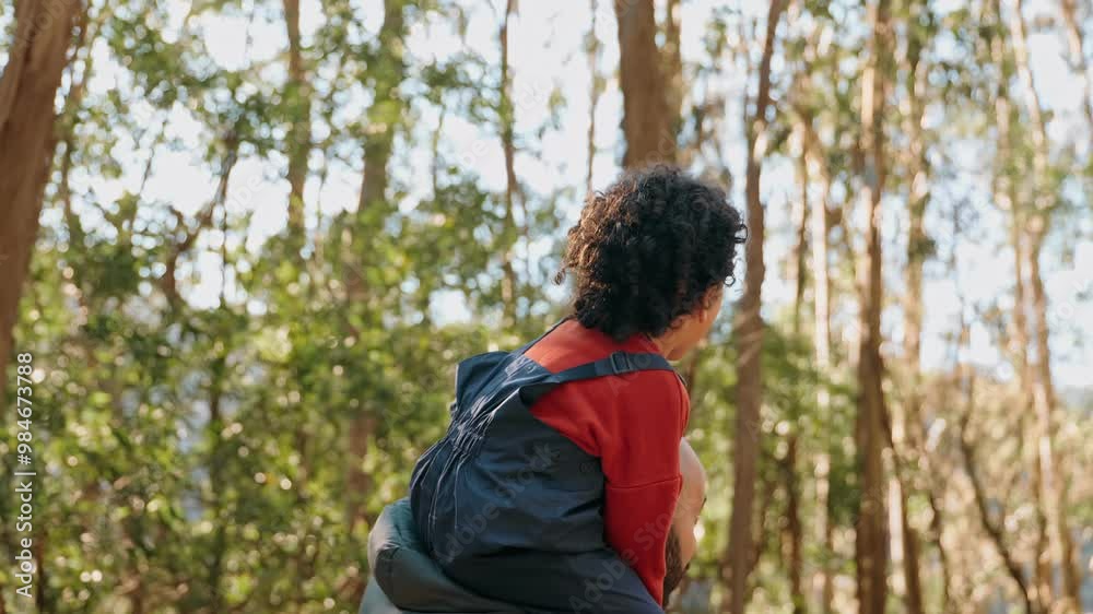 A toddler expresses delight while perched on an adult's shoulders during a forest adventure, encapsulating a moment of carefree joy and familial bond. A toddler expresses delight while perched on an adult's shoulders during a forest adventure, encapsulating a moment of carefree joy and familial bond.
