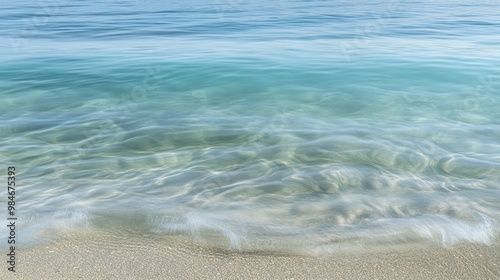 A serene view of clear water gently lapping against a sandy beach.