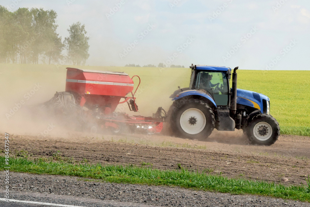 Fototapeta premium A modern tractor produces seeding with a multifunctional seeder