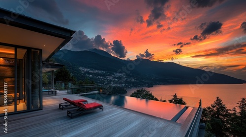 A modern villa overlooking a sunset-lit lake and mountains, featuring an infinity pool.