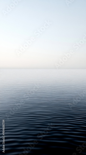 Calm water surface reflecting soft colors at dawn, creating a tranquil atmosphere in a serene coastal setting