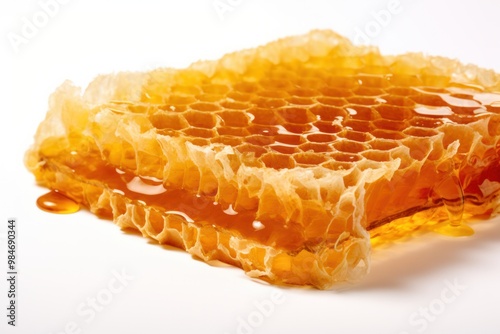 A honeycomb slice glistening under a spotlight, showcasing the intricate details of its wax cells and the honey within