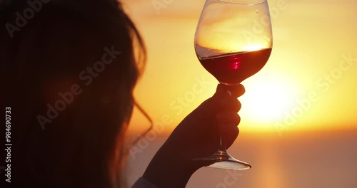 Slow motion silhouette woman tasting wine at the sea sunset