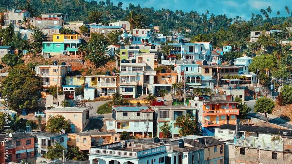 Picturesque panoramic view of idyllic city landscape on mountain hills. Colorful houses at the foot of a high mountain. Landscape of Santa Barbara de Samana province, Dominican Republic. Picturesque panoramic view of idyllic city landscape on mountain hills. Colorful houses at the foot of a high mountain. Landscape of Santa Barbara de Samana province, Dominican Republic.