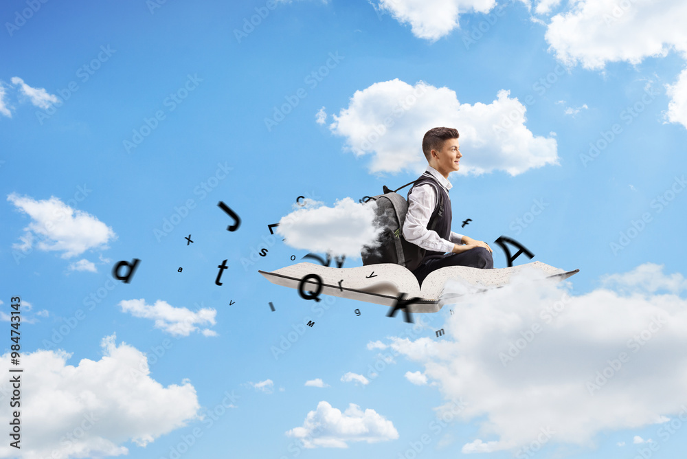 Teenage male student sitting on a book with letters and flying Teenage male student sitting on a book with letters and flying