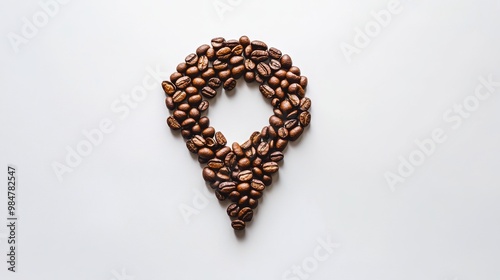 Location symbol creatively made from coffee beans on a clean white background.