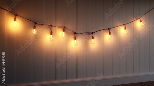 A clean white wall with a single string of lights hanging, medium angle photo