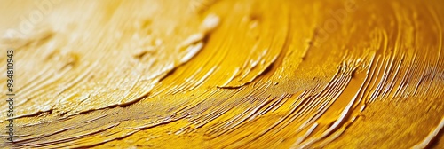 A detailed view of thick golden paint applied on canvas, highlighting the rich texture and artistic brush strokes. photo