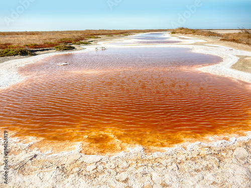 A watercourse of varying degrees of salinity from a hypersalted lake. The bitter-salty river. Red water because the bacteria Red color caused by bacterias Dunaliella salina, Salinibacter ruber
