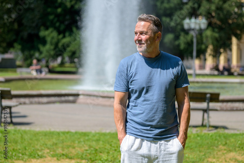 Mature Man Enjoying a Sunny Day by a Fountain in a Park