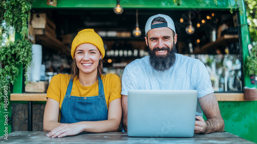 Smiling couple working at their food truck.