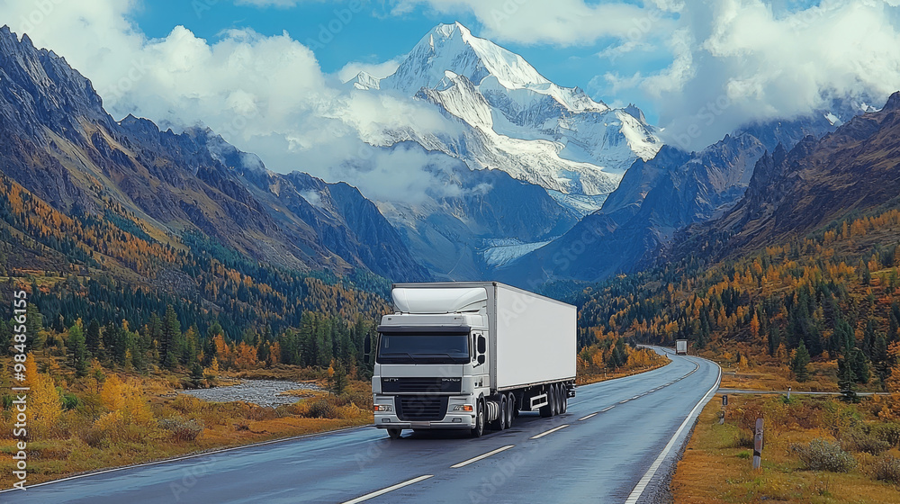 White semi-truck driving on a winding road in a mountain range. White semi-truck driving on a winding road in a mountain range.